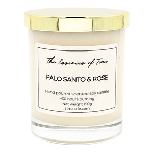 Palo Santo and Rose scented soy candle in a clear lass jar with golden dust cover.